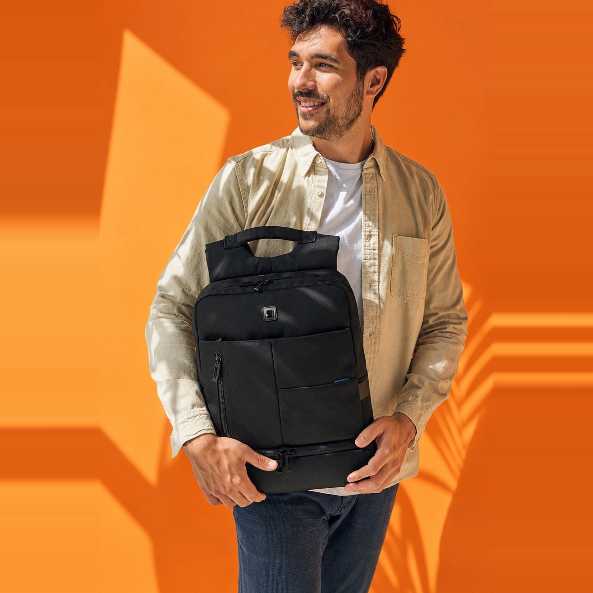 Hombrer posando con una mochila Gabol de color negro y muchos compartimentos.