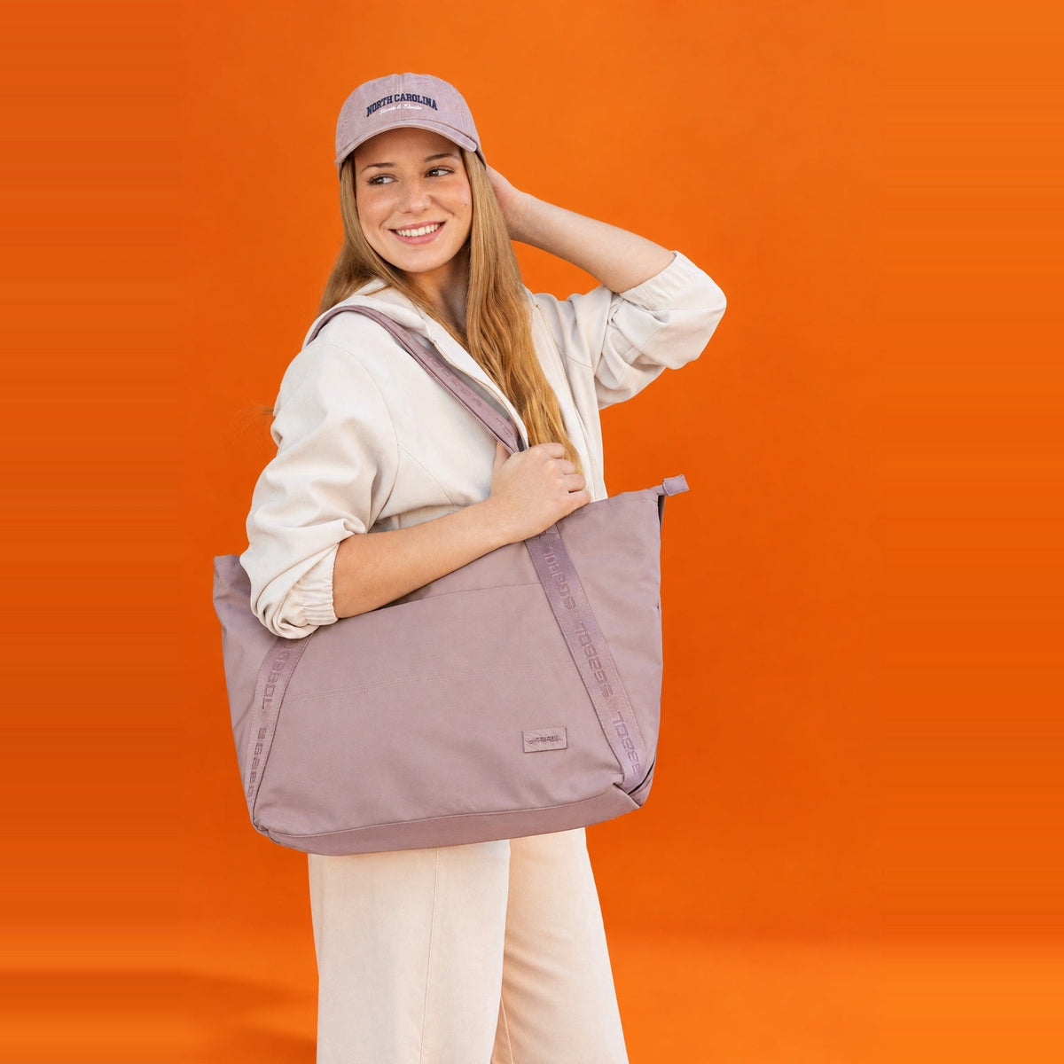 Una chica posando con un bolso shopper de color beige.
